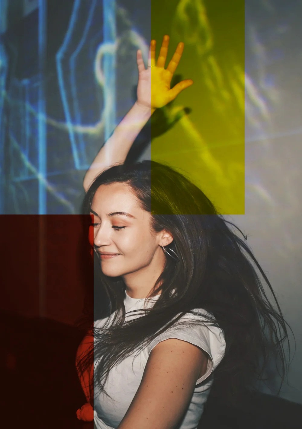 A woman dancing with one arm raised in front of the projections