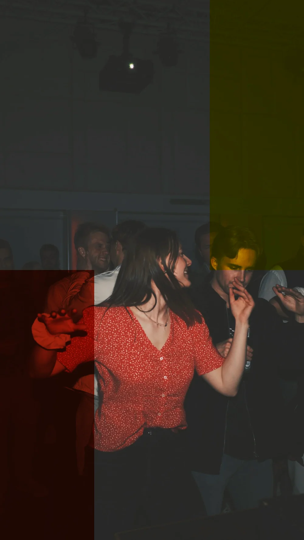 A woman in a red blouse dancing in the dark
