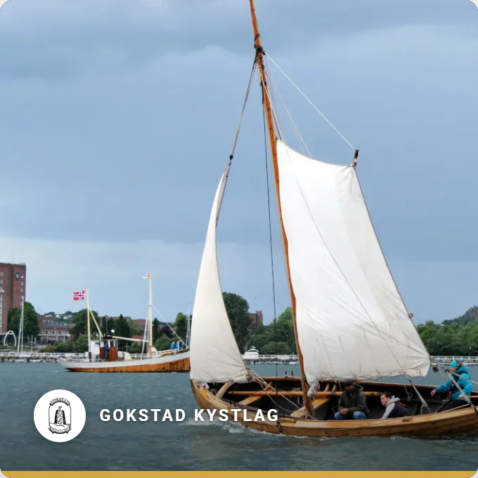 Gokstad Kystlag: a clinker built boat sailing under two white sails