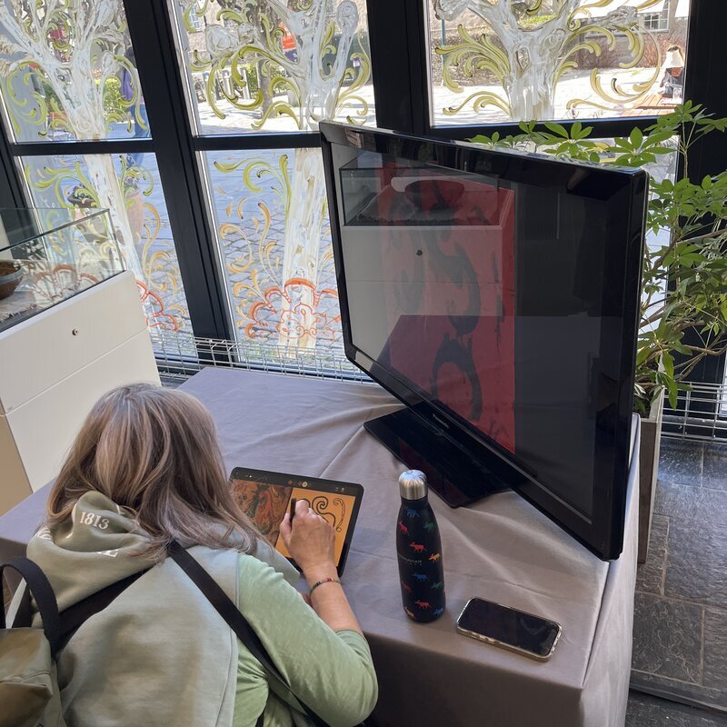 A visitor drawing at the installation